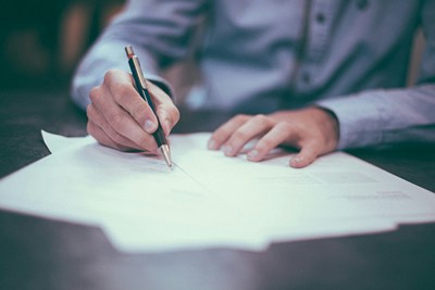 Employee signing agreement on desk at office